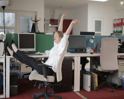 Man stretching in an office chair looking relaxed