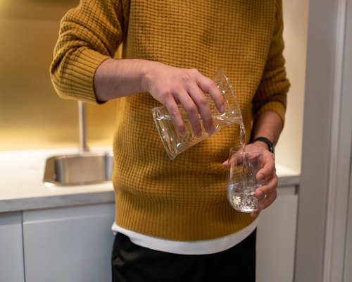 Man pouring water from a jug at home